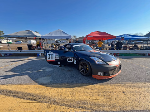 The dark blue 2007 Nissan 350Z parked in the paddock