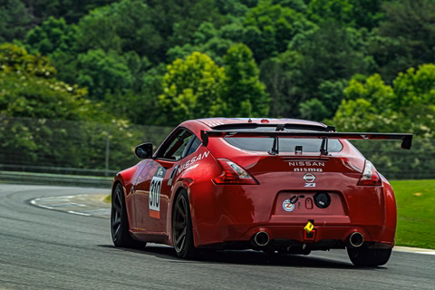Rear three-quarter view of the red 2011 Nissan 370Z cornering