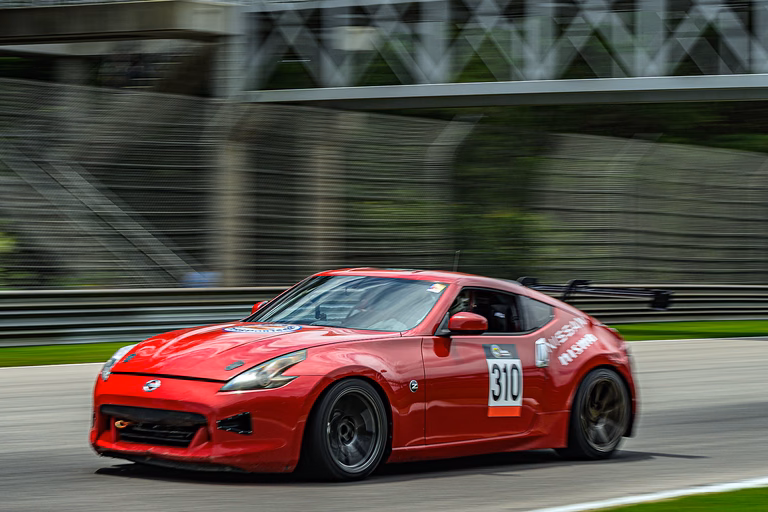 Plan Z Motorsports' bright red 2011 Nissan 370Z on track